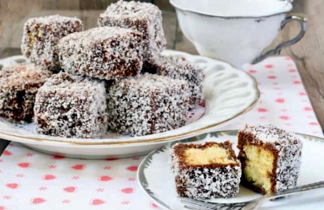 Prăjitură “Tăvălită” în nucă de cocos, cu blat pufos și sirop de ciocolată – Merită încercată cu prima ocazie